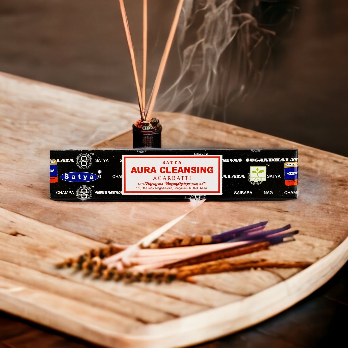 A box of Aura Cleansing Incense with a few incense sticks visible in the foreground, emitting a smoky fragrance.