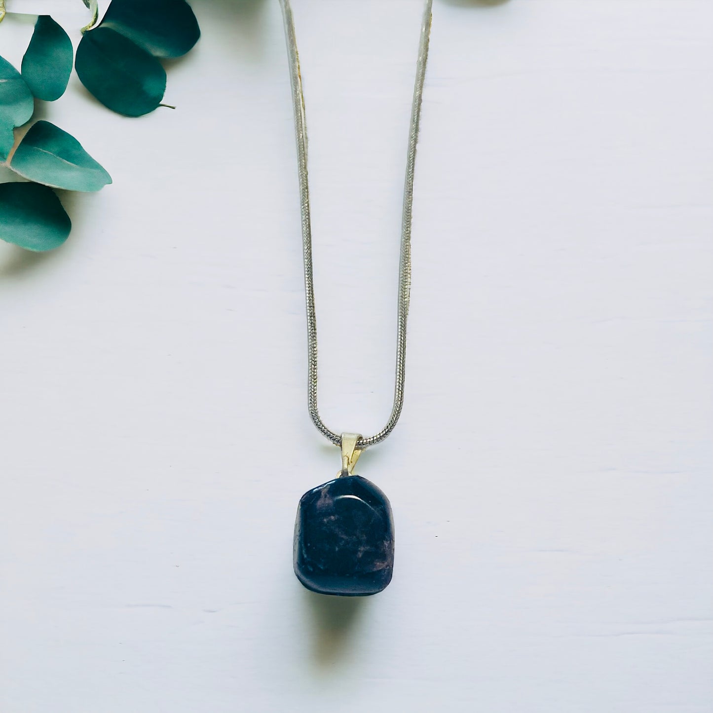 Polished amethyst gemstone pendant on chain, spiritual jewellery for calm and balance.