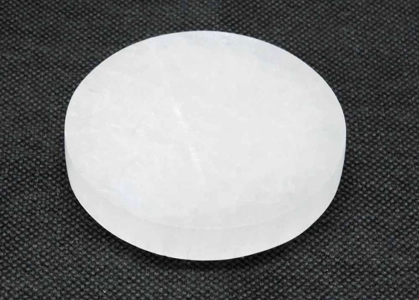 A round, white selenite charging plate for crystals.