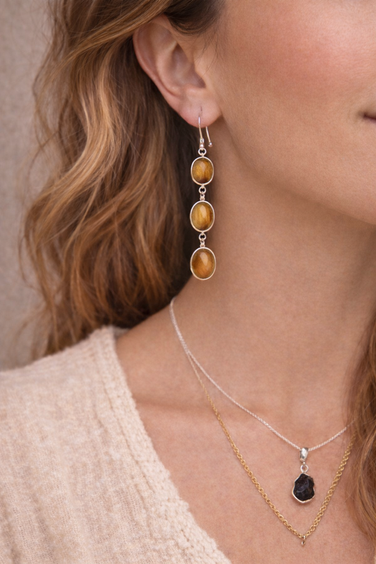 Close-up of a woman wearing tigers eye earrings 