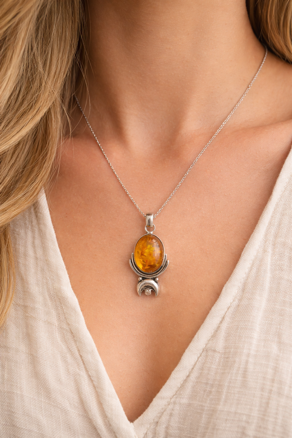 Amber pendant necklace on a model wearing a white top