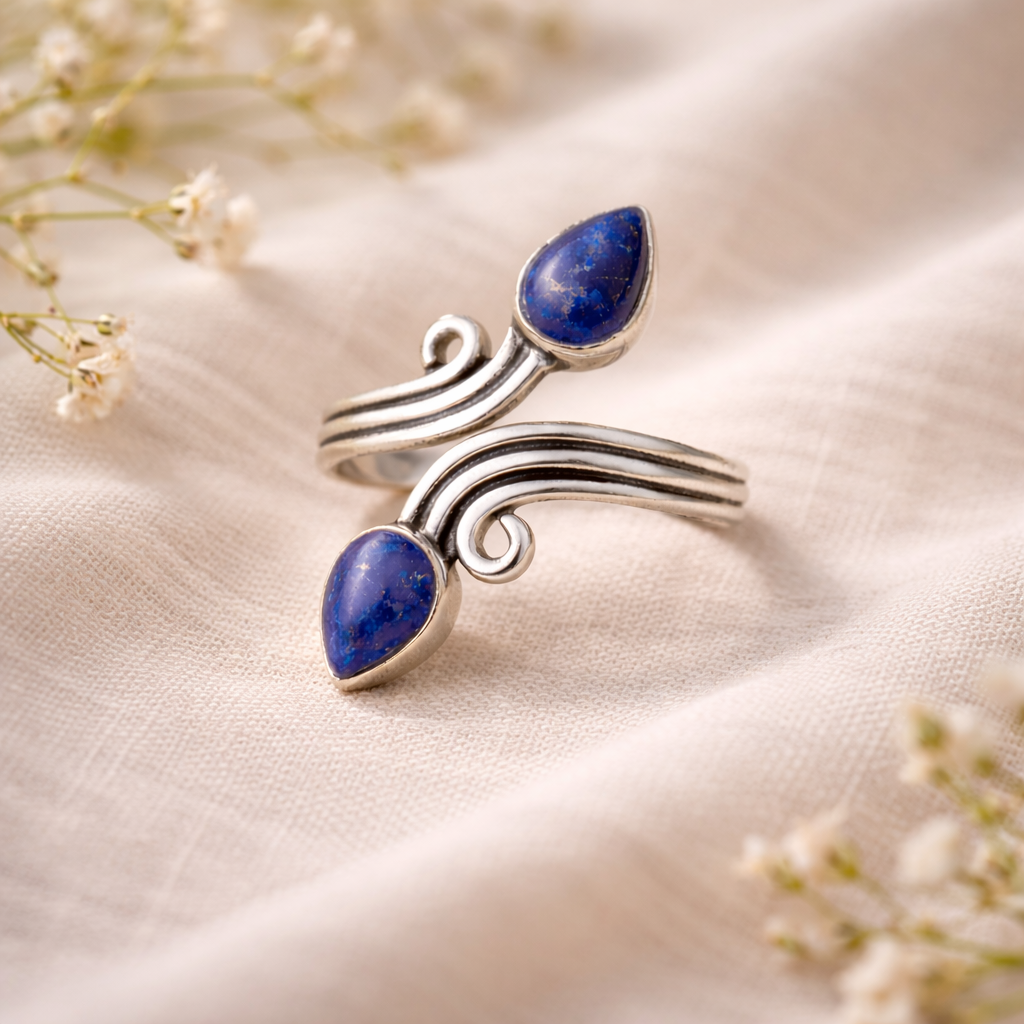 Silver ring with blue lapis lazulli gemstones on a soft fabric background