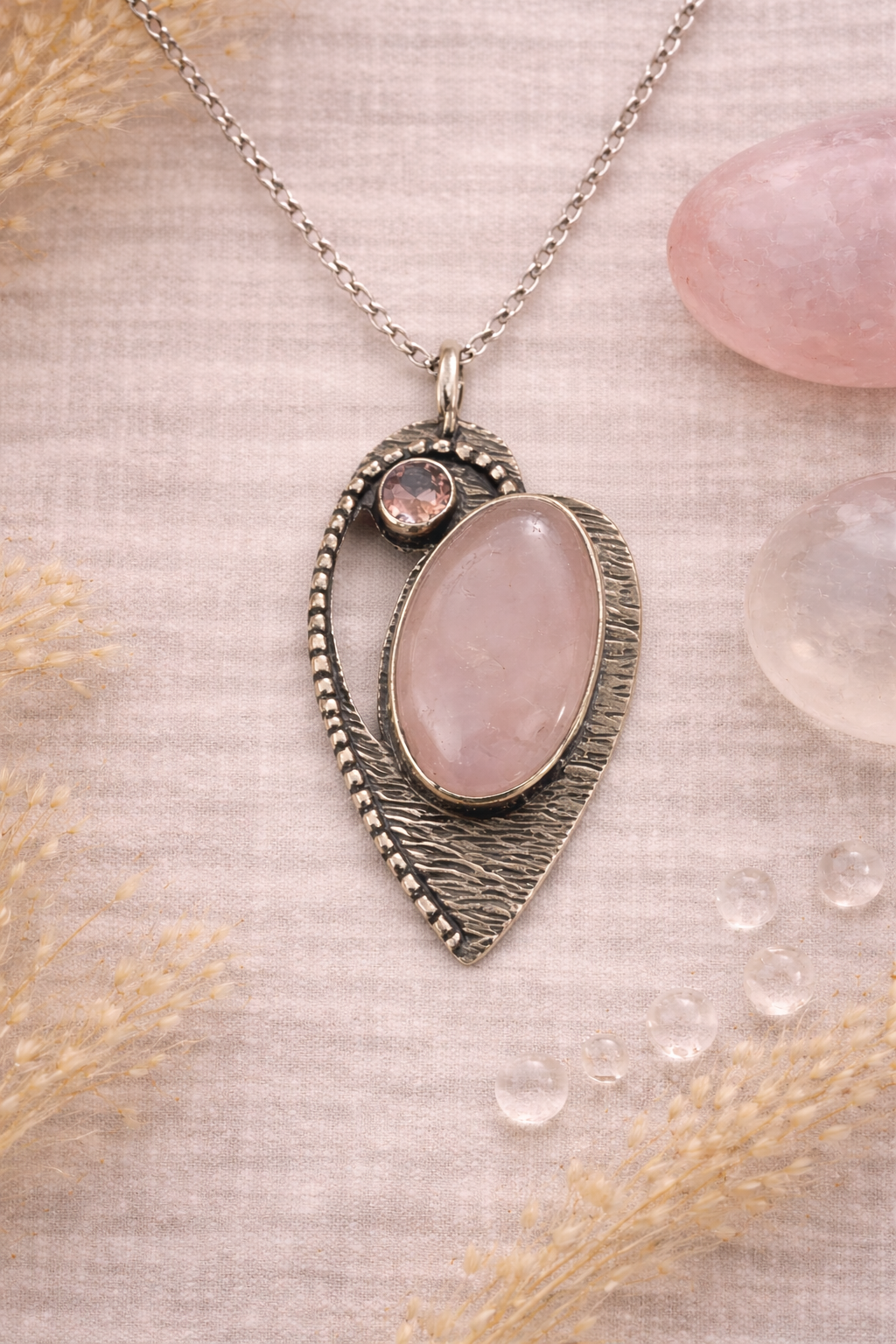 Heart shaped Necklace with a pink rose quartz stone pendant on a textured beige background