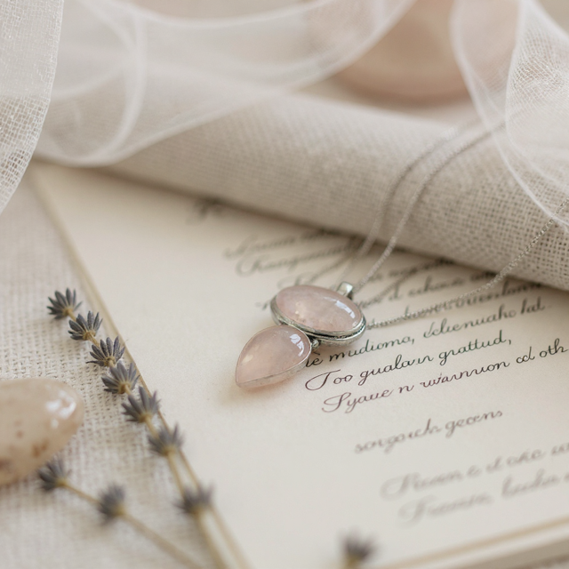 Necklace with pink stones on a textured fabric background