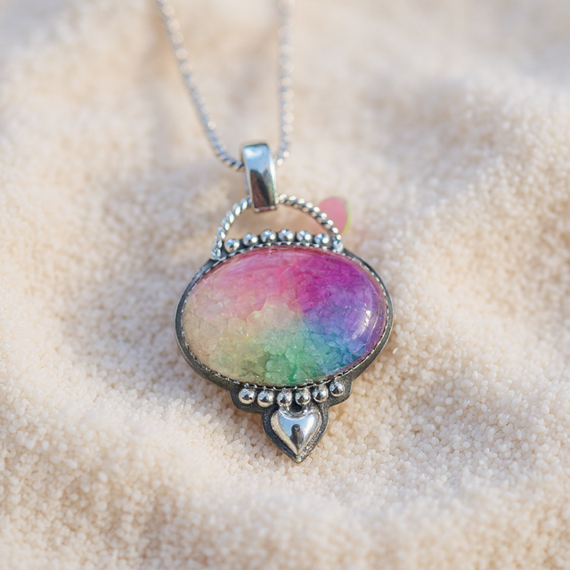 Multicolored pendant necklace on a textured beige surface