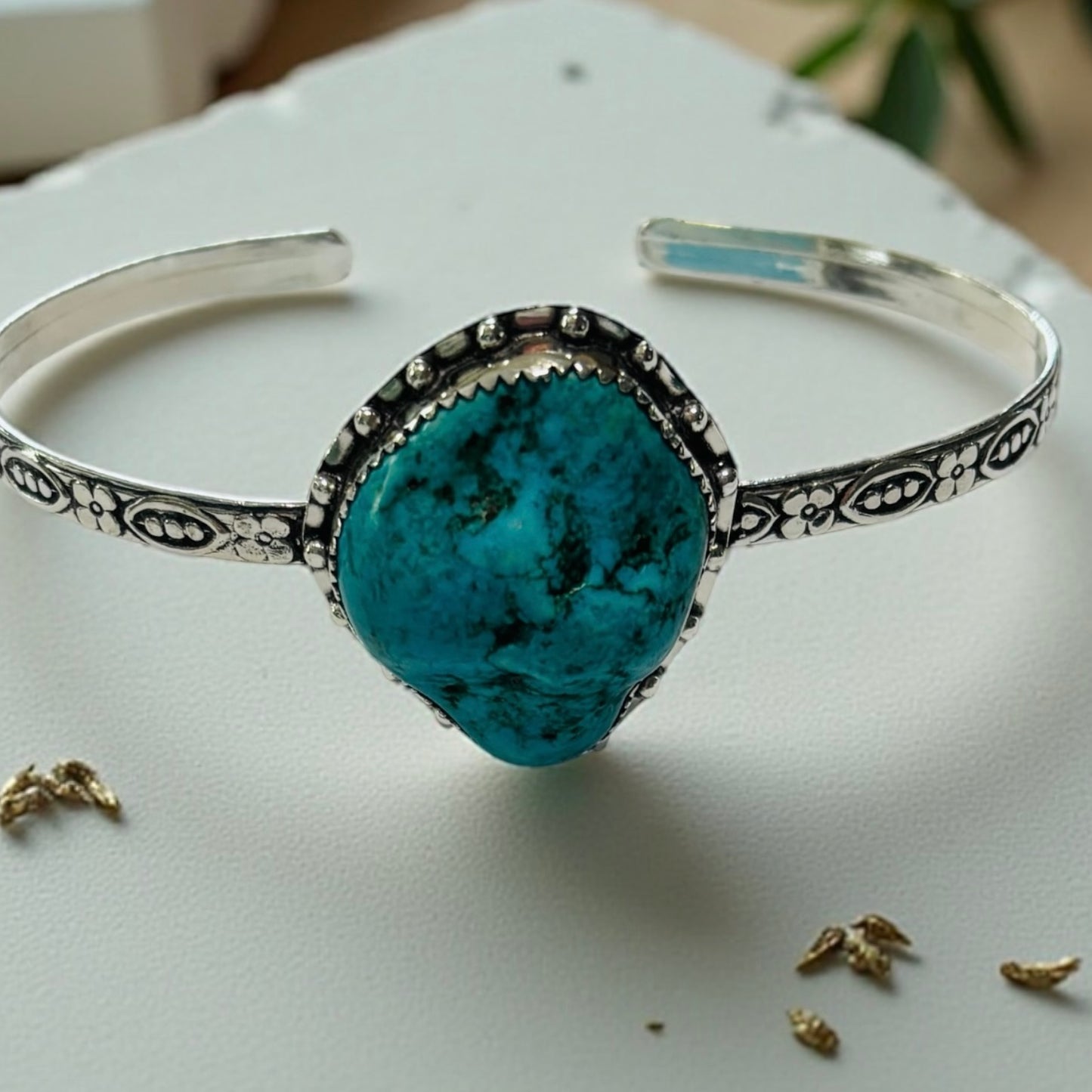 Silver bracelet with a turquoise stone on a white surface