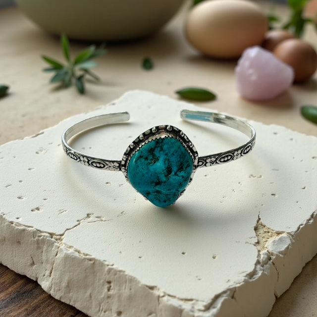 Silver bracelet with a turquoise stone on a white stone surface
