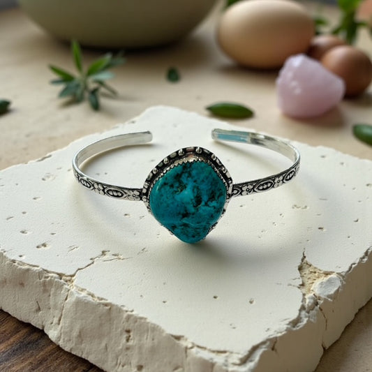 Silver bracelet with a turquoise stone on a white stone surface