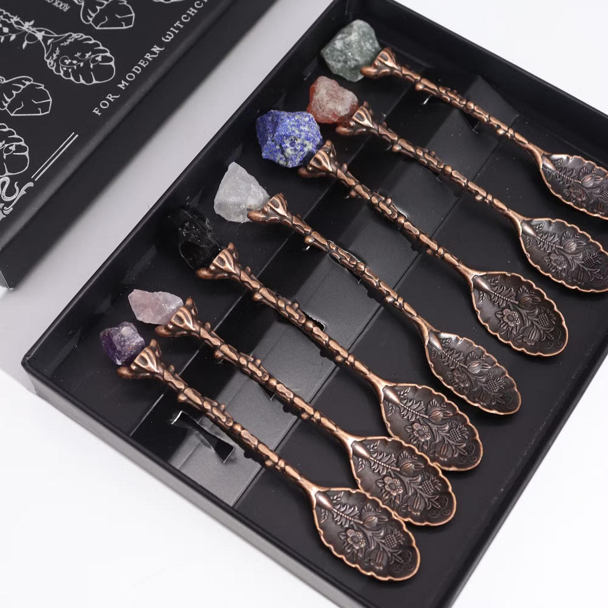 Set of 7 gemstone ritual spoons with bronze-toned floral handles